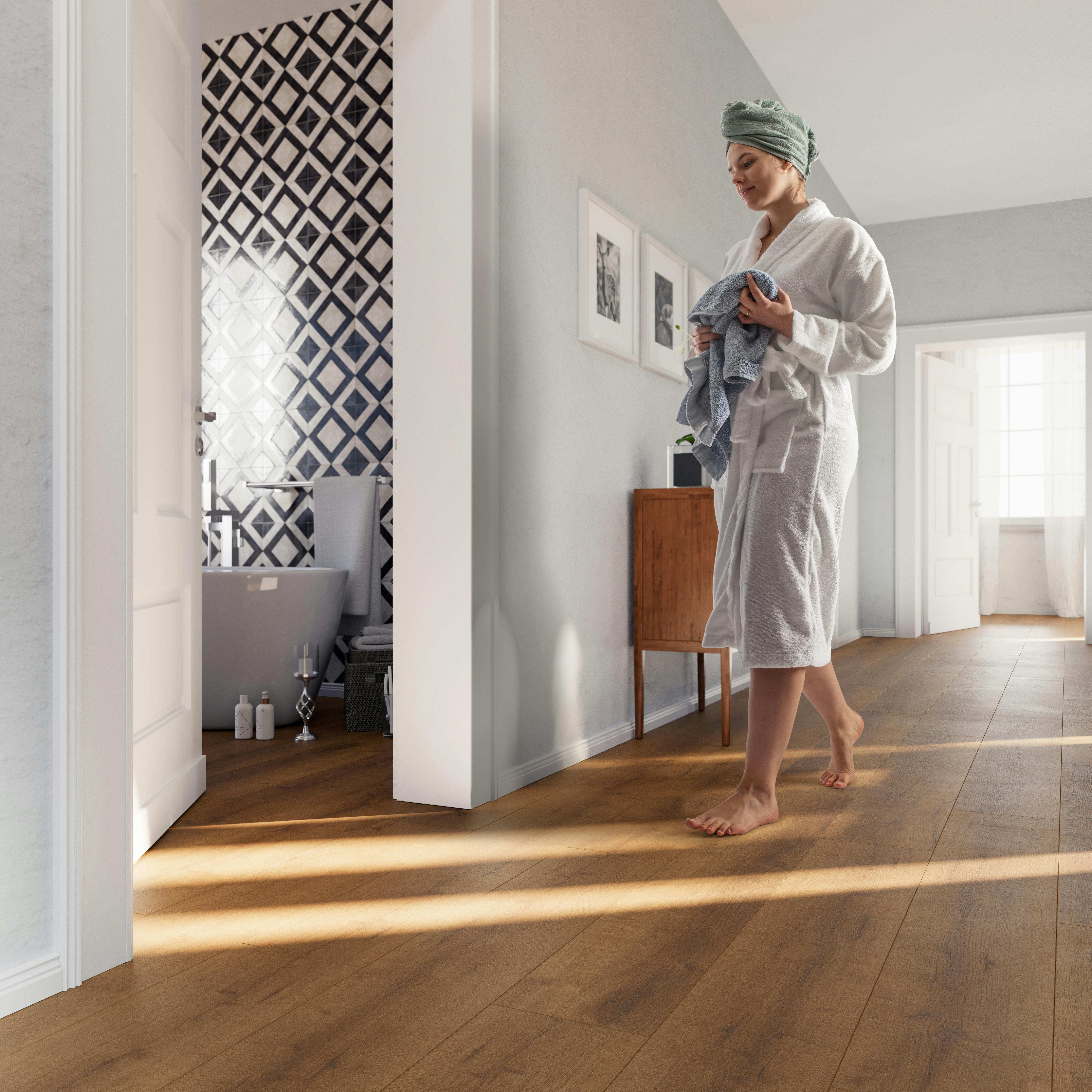 Dame im Bademantel l&auml;uft ins Badezimmer