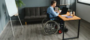 K&ouml;rperliche eingeschr&auml;nkte Dame im Rollstuhl steht gemeinsam mit einem Freund auf Klick-Vinyl