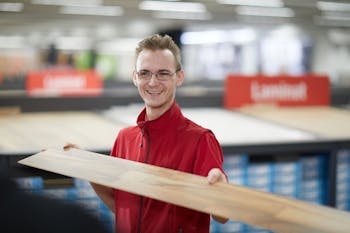 Junger Mann hält Vinylboden in der Hand