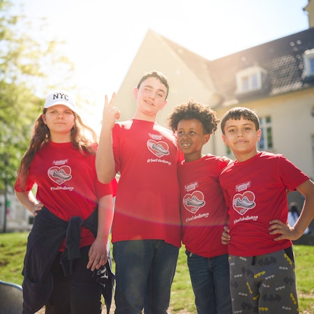 Kinder mit LaminatDEPOT Laufchallenge T-Shirt vor einem Haus